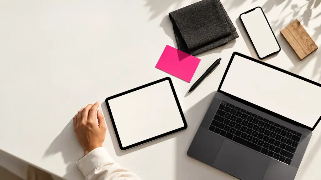 Teléfono, agenda digital y computador en una misma mesa de trabajo.
